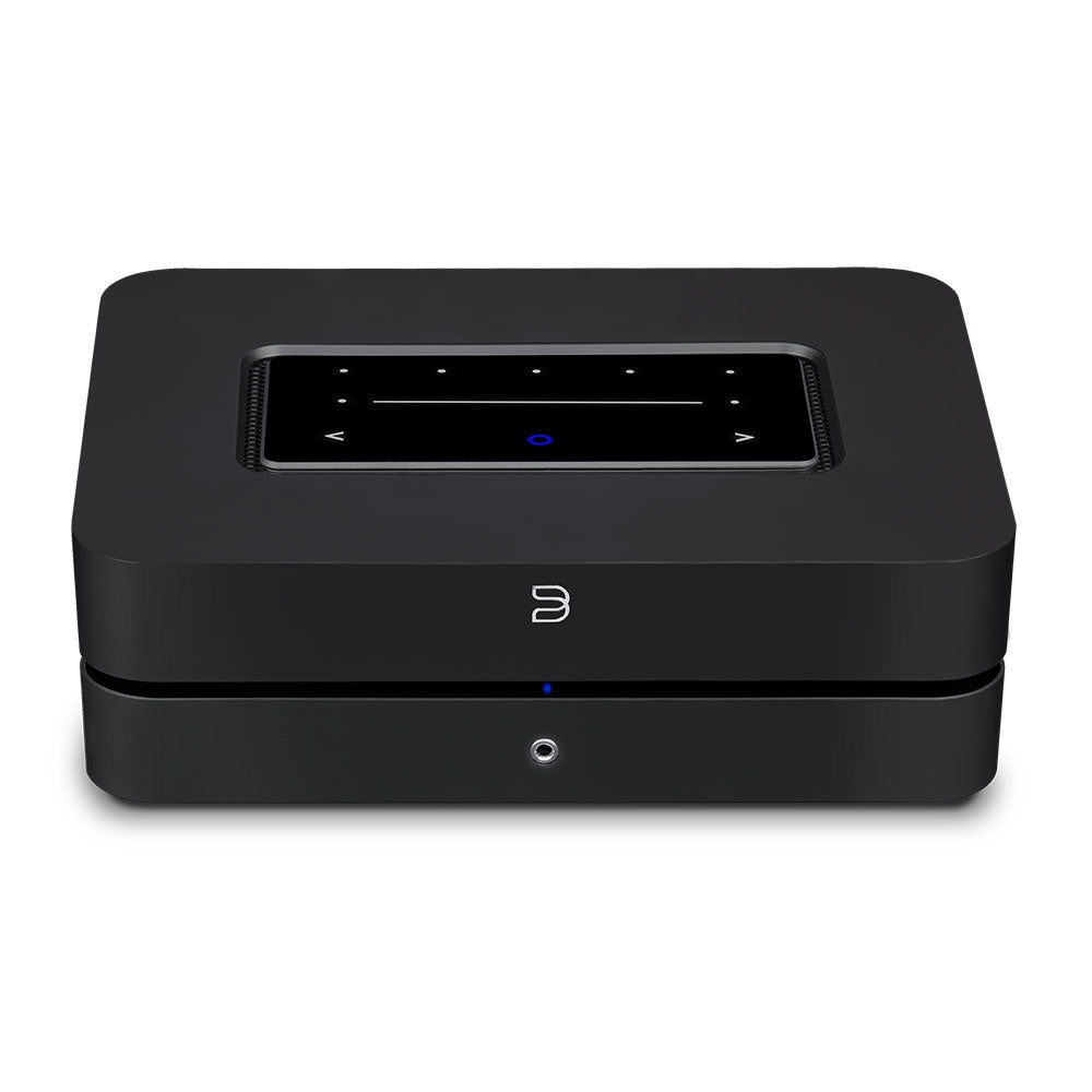 Die Bluesound POWERNODE in Schwarz ist ein rechteckiges elektronisches Gerät mit Touch-Control-Panel, digitalem Display und Tasten auf der Oberseite sowie einer kleinen runden blauen Kontrollleuchte auf der Vorderseite, das High-End-Audio-Performance liefert.