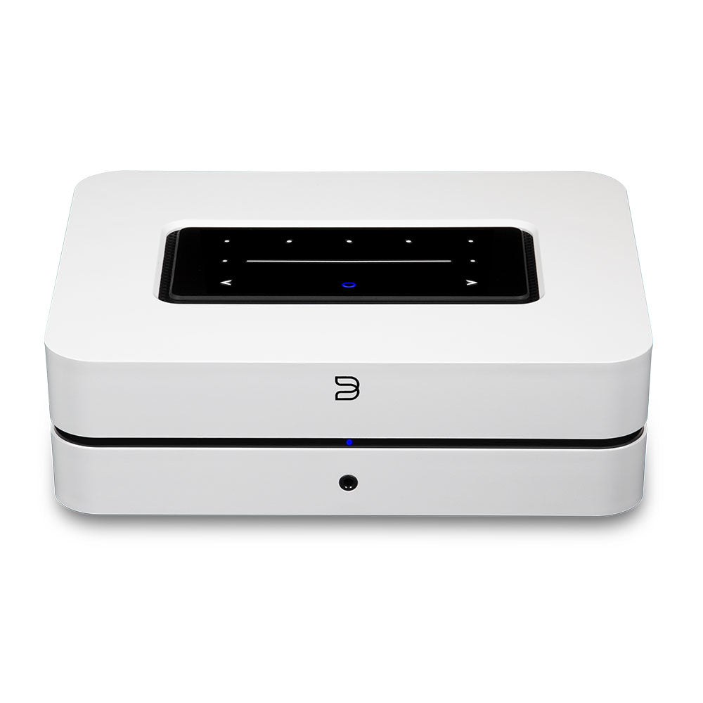 Der Bluesound POWERNODE in Weiß ist ein kompakter, rechteckiger Streaming-Vollverstärker mit schwarzem Touchpanel auf der Oberseite und blauer Frontanzeige, der High-End Audio-Performance für kabelloses Audio-Streaming liefert.
