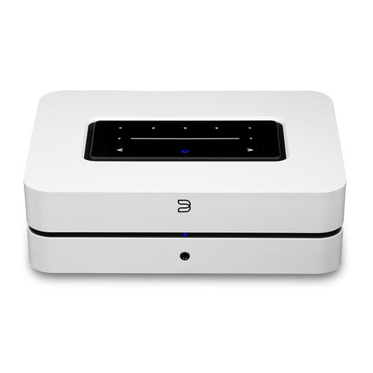 Der Bluesound POWERNODE in Weiß ist ein kompakter, rechteckiger Streaming-Vollverstärker mit schwarzem Touchpanel auf der Oberseite und blauer Frontanzeige, der High-End Audio-Performance für kabelloses Audio-Streaming liefert.