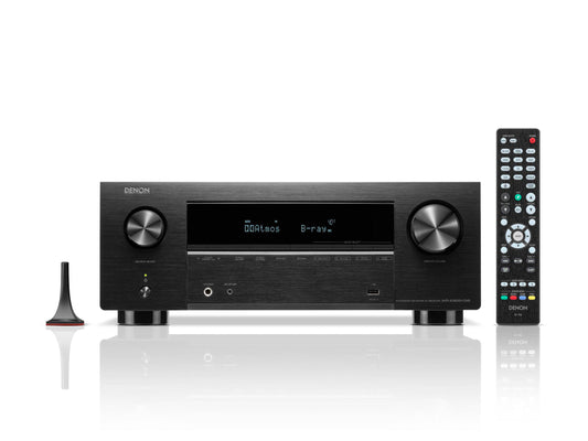 Ein schwarzer Denon AVR-X2800H DAB AV-Receiver (Schwarz) mit Display, zwei großen Drehreglern, Fernbedienung und Einmessmikrofon wird auf weißem Hintergrund gezeigt und hebt 8K-Videoqualität und Dolby Atmos-Unterstützung hervor.