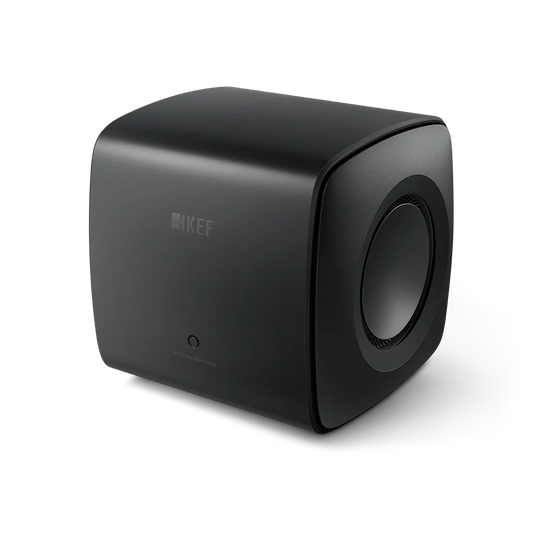 Der KEF KC62 Subwoofer in Carbon Black ist ein kompakter, würfelförmiger Lautsprecher mit abgerundeten Kanten, dezentem Branding auf der Vorderseite, einer sichtbaren seitlichen Lautsprechermembran und einem hochmodernen Design mit innovativer Uni-Core®-Technologie.