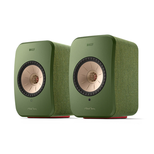 Ein Paar KEF LSX II Aktivlautsprecher in Salbeigrün mit Stofftextur, mit roségoldenen konzentrischen Treibern, Michael Youngs Unterschrift auf der Vorderseite und mit High-Fidelity-Sound.
