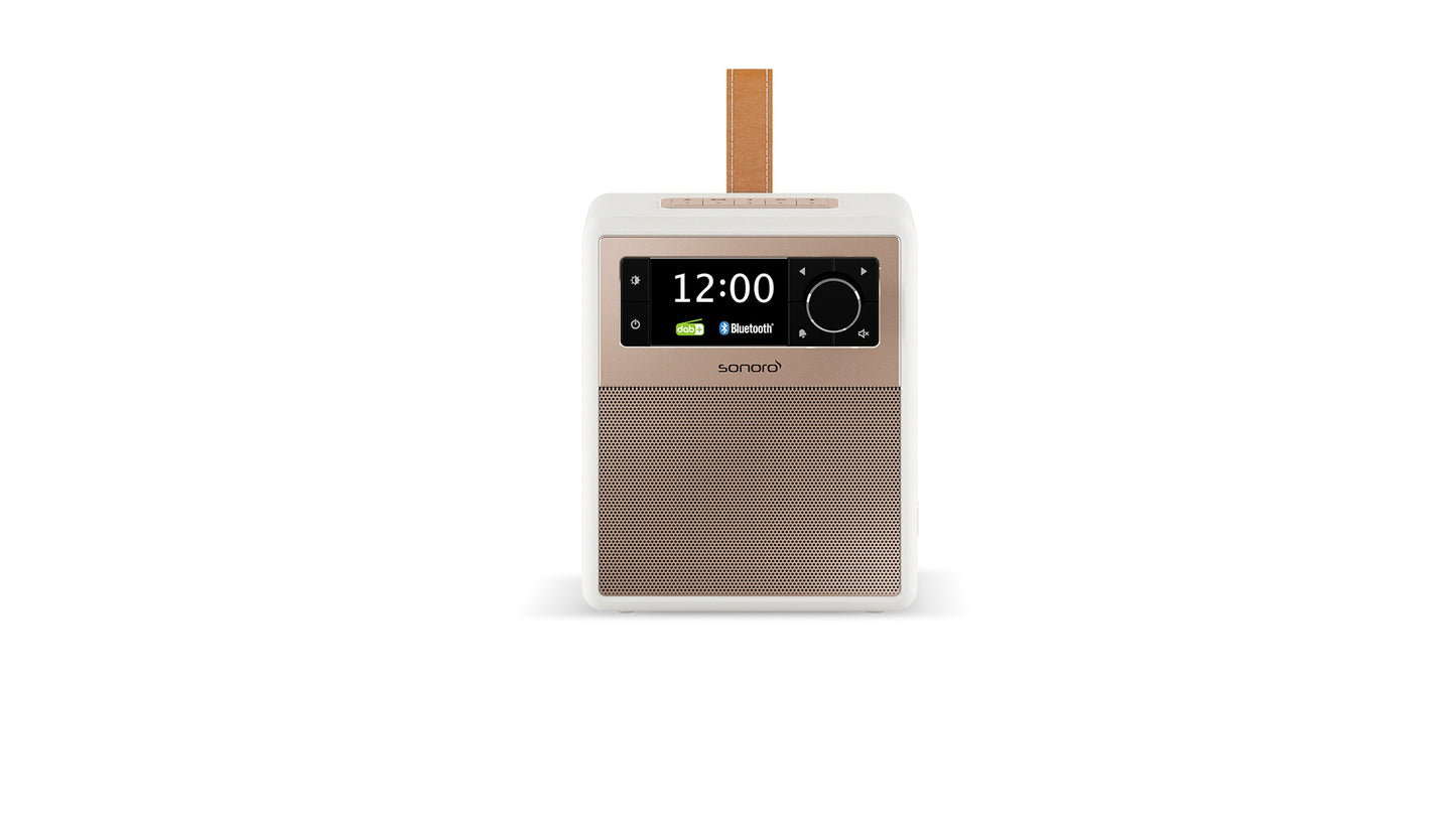 Das Sonoro Easy in Weiß (matt) - Rosé ist ein kompaktes, modernes Digitalradio mit hochwertigem Klang, Digitalanzeige (12:00), Bluetooth-Symbol, Batteriesymbol, Lederband für Mobilität und Lautsprechergitter direkt unterhalb des Displays.
