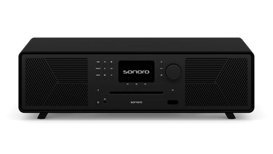 Ein Sonoro Meisterstück (Gen.2) in Schwarz (matt) - Schwarz mit Digitalanzeige, Tasten, zentralem Drehknopf, Dynamic Bass Funktion für beste Audioqualität und Lautsprechergittern auf beiden Seiten - dargestellt auf vier kurzen Beinen vor weißem Hintergrund.