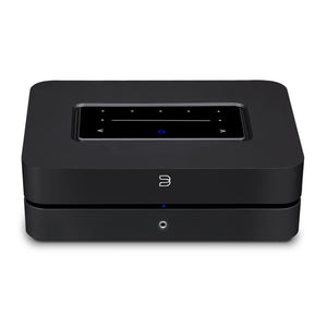 Die Bluesound POWERNODE in Schwarz ist ein rechteckiges elektronisches Gerät mit Touch-Control-Panel, digitalem Display und Tasten auf der Oberseite sowie einer kleinen runden blauen Kontrollleuchte auf der Vorderseite, das High-End-Audio-Performance liefert.