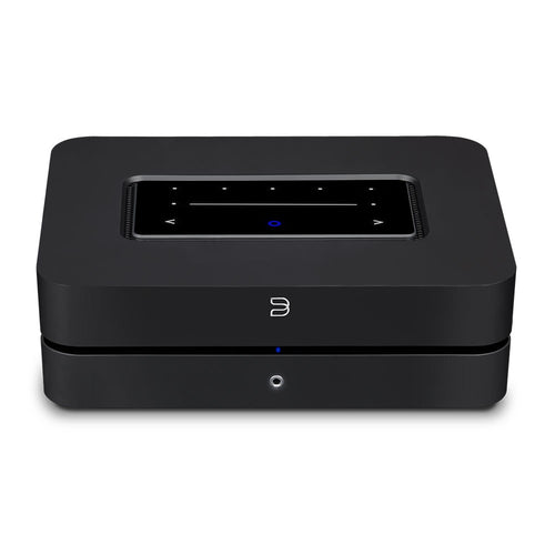 Die Bluesound POWERNODE in Schwarz ist ein rechteckiges elektronisches Gerät mit Touch-Control-Panel, digitalem Display und Tasten auf der Oberseite sowie einer kleinen runden blauen Kontrollleuchte auf der Vorderseite, das High-End-Audio-Performance liefert.