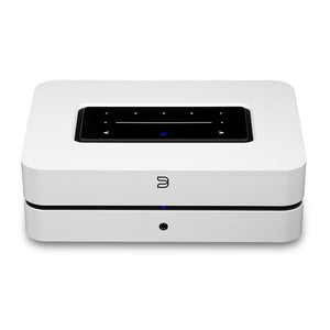 Der Bluesound POWERNODE in Weiß ist ein kompakter, rechteckiger Streaming-Vollverstärker mit schwarzem Touchpanel auf der Oberseite und blauer Frontanzeige, der High-End Audio-Performance für kabelloses Audio-Streaming liefert.