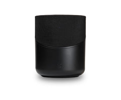 Der Bluesound PULSE M in Schwarz hat eine stoffbespannte Oberseite, eine glatte Unterseite und ein kleines Frontlogo. Dieser kabellose Lautsprecher bietet HiFi-Stereoklang und 360° Klangverteilung. Abgebildet vor einem weißen Hintergrund.