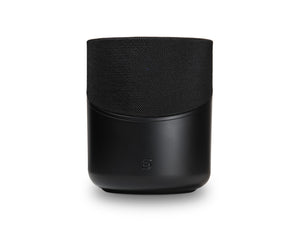 Der Bluesound PULSE M in Schwarz hat eine stoffbespannte Oberseite, eine glatte Unterseite und ein kleines Frontlogo. Dieser kabellose Lautsprecher bietet HiFi-Stereoklang und 360° Klangverteilung. Abgebildet vor einem weißen Hintergrund.