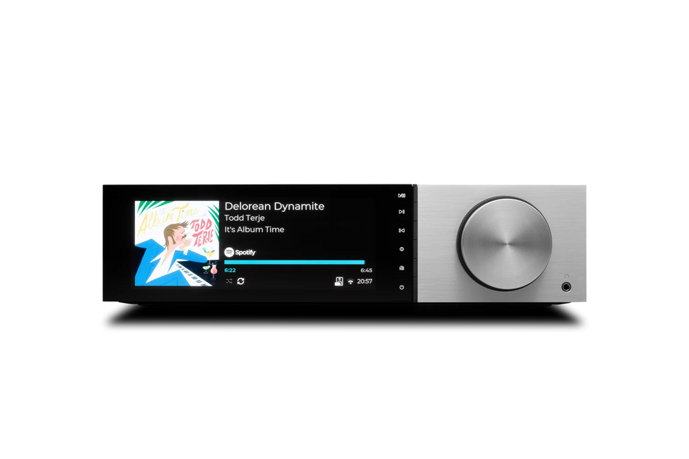 Der Cambridge Audio EVO 150 Delorean Edition All-in-One Player in Silber verfügt über einen großen silbernen Lautstärkeregler und zeigt den Song "Delorean Dynamite" von Todd Terje aus "It's Album Time" an, der gerade auf Spotify läuft.