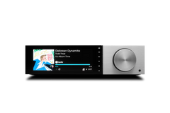 Der Cambridge Audio EVO 150 Delorean Edition All-in-One Player in Silber verfügt über einen großen silbernen Lautstärkeregler und zeigt den Song "Delorean Dynamite" von Todd Terje aus "It's Album Time" an, der gerade auf Spotify läuft.
