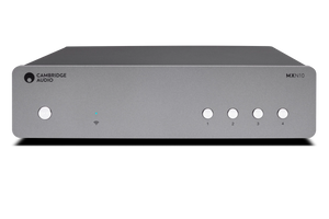 Frontansicht des Cambridge MXN10 Kompakt-Netzwerkplayers in Luna Grey, mit Power- und vier nummerierten Tasten rechts, Kontrollleuchten links, und Unterstützung für hochauflösende Musikformate über die StreamMagic App.