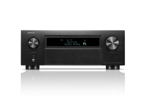 Frontansicht des Denon AVC-X6800H AV-Receivers in Schwarz mit großen Lautstärke- und Eingangsknöpfen, Display mit Blu-ray Dolby Atmos, HEOS® Built-in Logo sowie diversen Bedientasten. Das Gerät spiegelt sich auf einer glänzenden Oberfläche.