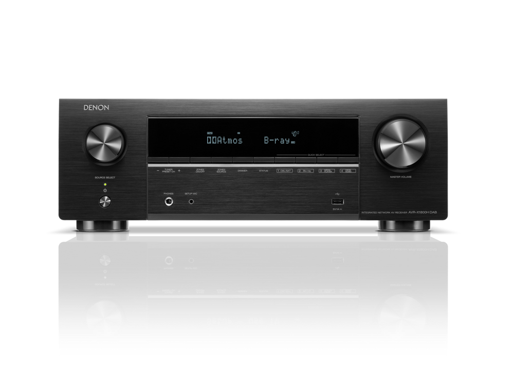 Der Denon AVR-X1800H DAB AV-Receiver in Schwarz verfügt über 8K-Videotechnologie, ein digitales Display mit DOLBY Atmos und B-ray, mehrere Bedienknöpfe, Tasten und Eingangsanschlüsse, die auf einem weißen Hintergrund mit einer reflektierenden Oberfläche darunter dargestellt werden.