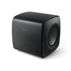 Der KEF KC62 Subwoofer in Carbon Black ist ein kompakter, würfelförmiger Lautsprecher mit abgerundeten Kanten, dezentem Branding auf der Vorderseite, einer sichtbaren seitlichen Lautsprechermembran und einem hochmodernen Design mit innovativer Uni-Core®-Technologie.
