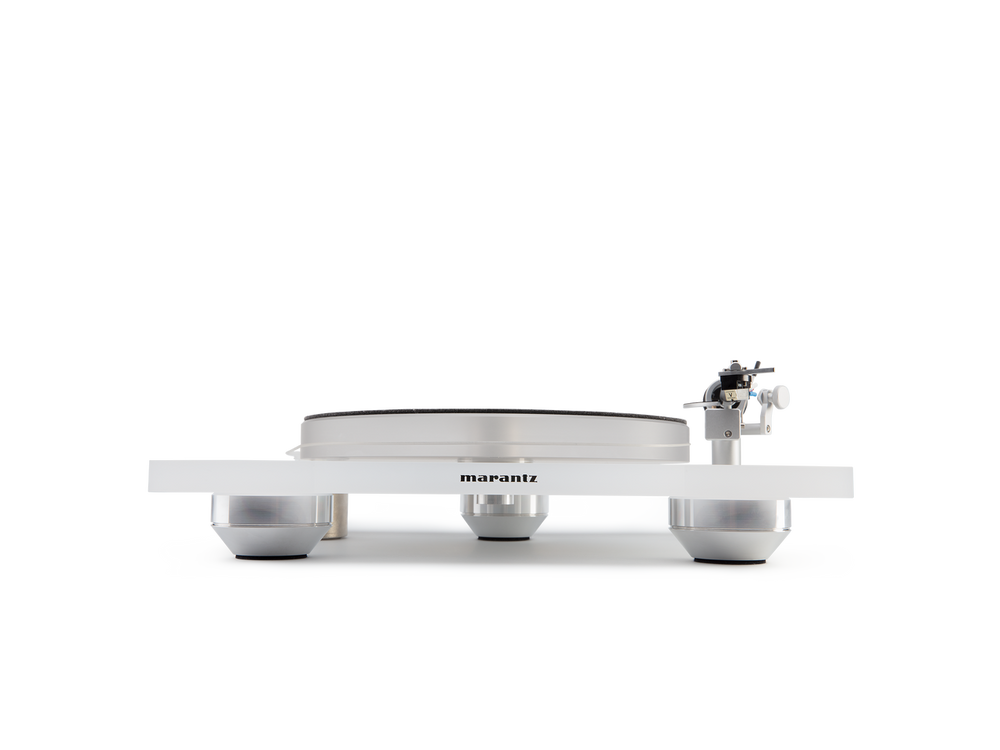 Der Marantz TT-15S1 Plattenspieler in Weiß wird von vorne gezeigt, wobei sein minimalistisches Präzisionsdesign, runde Plattenteller und drei Metallfüße vor neutralem Hintergrund hervorgehoben werden.