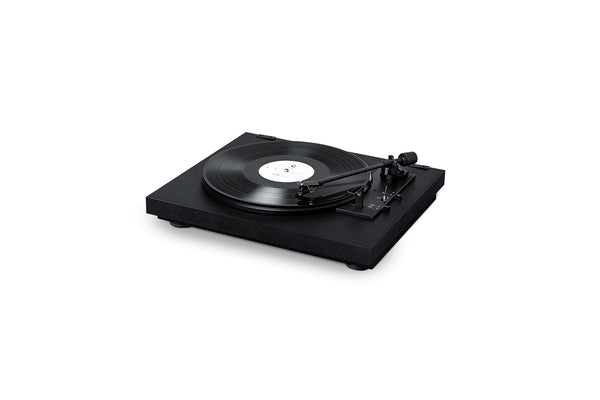 Der Pro-Ject A1, ein schwarzer, vollautomatischer Plattenspieler mit einem Ortofon OM10 MM Tonabnehmer und einem Tonarm, der auf dem Plattenteller über einer Schallplatte positioniert ist, wird vor einem schlichten weißen Hintergrund gezeigt.