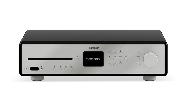 Der Sonoro Maestro Verstärker besticht durch sein modernes Design mit silberner Frontplatte, zentralem schwarzem Display, verschiedenen Tasten, CD-Einschub auf der linken Seite und einem großen Lautstärkeregler auf der rechten Seite.