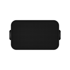 Der Sonos Outdoor Speaker von Sonos und Sonance Paar by Soundreference ist ein rechteckiger, schwarzer, tragbarer Lautsprecher mit abgerundeten Ecken, strukturiertem Frontgitter, seitlichen Drehreglern und wetterfestem Design, abgebildet vor einem weißen Hintergrund.