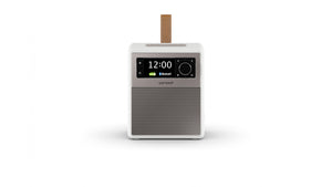 Das Sonoro Easy ist ein modernes Digitalradio in hochglänzendem Weiß-Silber mit zentralem Display (zeigt "12:00"), Bluetooth-Symbol und Holz-Tragegriff für Mobilität. Die Marke sonoro steht für hochwertigen Klang unter dem Display.