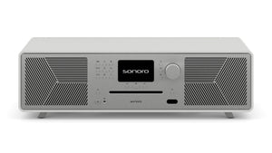 Ein modernes, rechteckiges Sonoro Meisterstück (Gen.2) Audiosystem in Weiß (matt)-Silber, ausgestattet mit zentralem Digitaldisplay, Bedientasten, großem Drehknopf, seitlichen Lautsprechergittern, CD-Einschub, Dynamic Bass Funktion und kleinen Füßen.