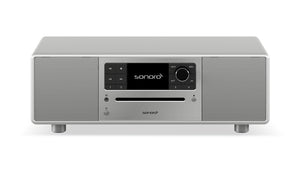 Das Sonoro Prestige in hochglänzendem Silber bietet exzellente Akustik durch zwei Lautsprecher pro Seite, zentrales Display, Bedientasten, große Lautstärkeregler und CD-Slot-ideal für vielfältige Musikquellen auf vier kurzen Beinen.