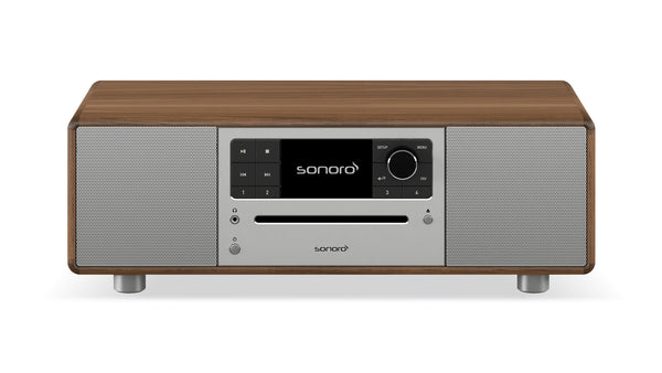 Das Sonoro Prestige Audiosystem in Walnuss-Silber verfügt über ein modernes Design mit zentralem Bedienfeld, Display, Tasten und zwei silbernen Lautsprechergittern für exzellente Akustik.