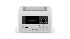 Der Sonoro Relax in Weiß (hochglänzend) - Silber verfügt über ein digitales Display, Bedientasten, einen großen Drehknopf, USB-Anschluss und ein oberes Lautsprechergitter - ideal für Wellness-Momente oder Meditationsübungen zu Hause.