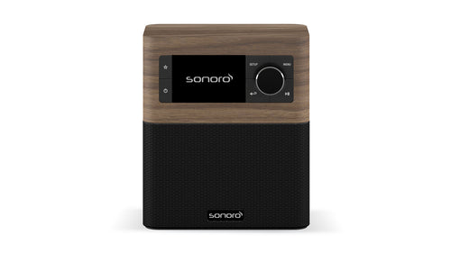 Das Sonoro Stream ist ein kompaktes Tisch-DAB+-Digitalradio im Walnuss-Dekor mit schwarzem Lautsprechergitter, Frontdisplay, Tasten und Wählscheibe. Das Sonoro-Logo erscheint sowohl auf dem Display als auch auf dem Gitter.